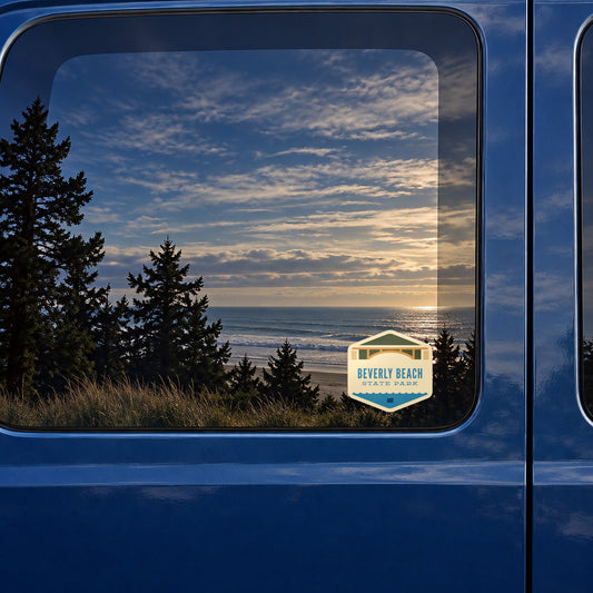 Beverly Beach sticker on the rear window of a van, reflecting a beach at sunset
