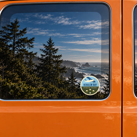 Nehalem Bay sticker on the rear window of a van, reflecting a rocky coast with sea stacks