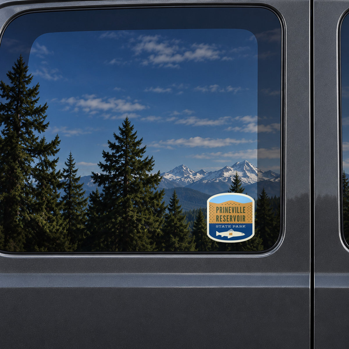 Prineville Reservoir sticker on the rear window of a van, reflecting snowy Cascade peaks