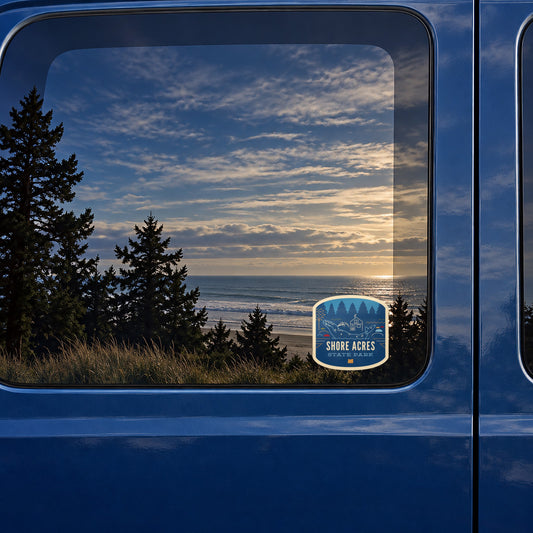Shore Acres Holiday sticker on the rear window of a van, reflecting a beach at sunset