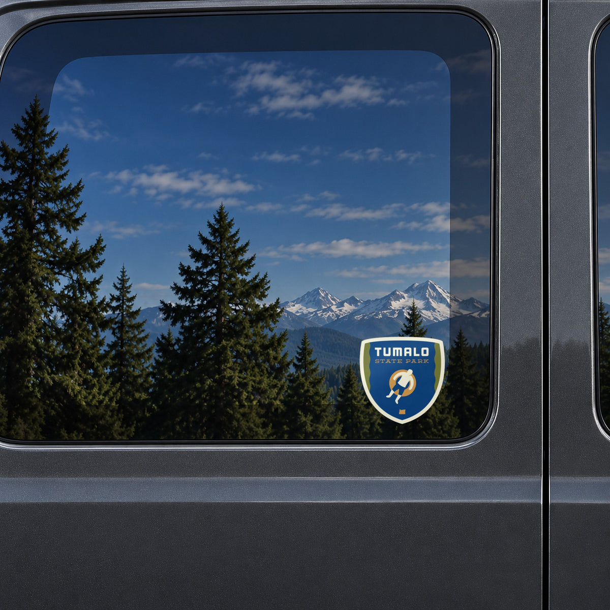 Tumalo sticker on the rear window of a van, reflecting snowy Cascade peaks