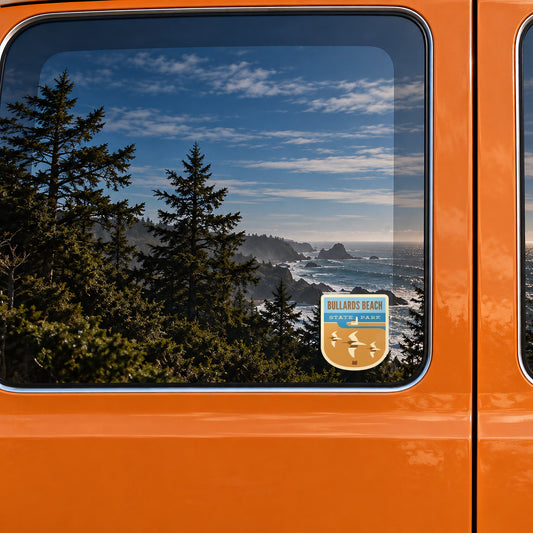 Bullards Beach sticker on the rear window of a van, reflecting a rocky coast with sea stacks