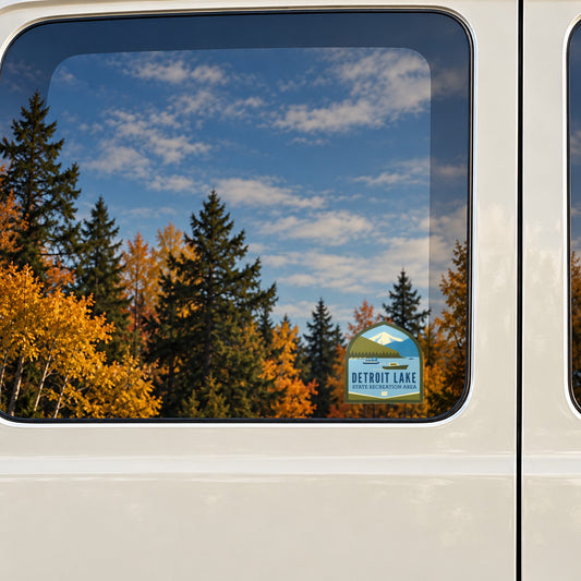 Detroit Lake sticker on the rear window of a van, reflecting fall colour