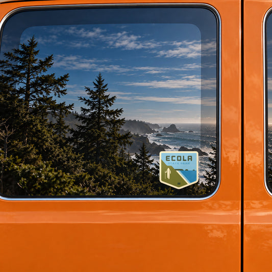 Ecola sticker on the rear window of a van, reflecting a rocky coast with sea stacks